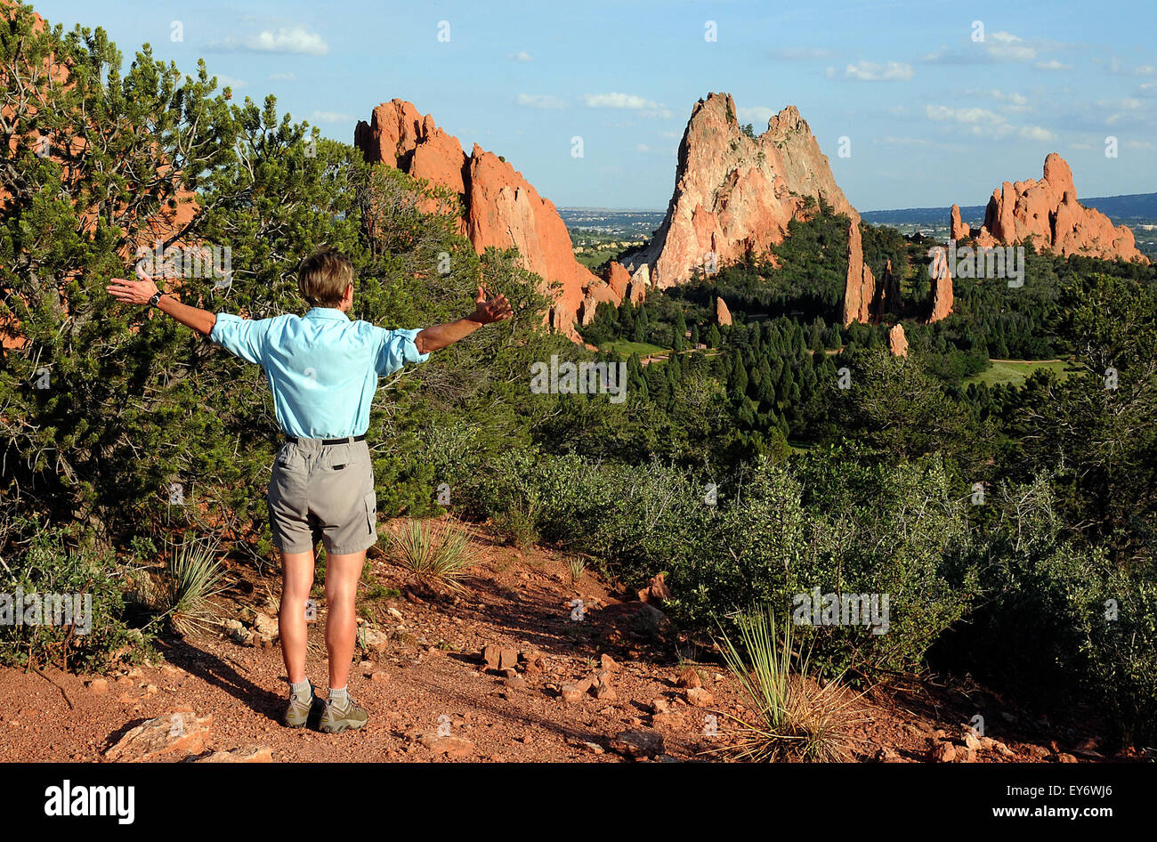 A hiker enjoys the expansive view into the Central Garden from one of the many trails in the Garden of the Gods. The Garden of the Gods is one of the most popular city parks in the United States and offers urban hiking, rock climbing, horseback riding and cycling within just a few minutes of the city of Colorado Springs, Colorado. Stock Photo