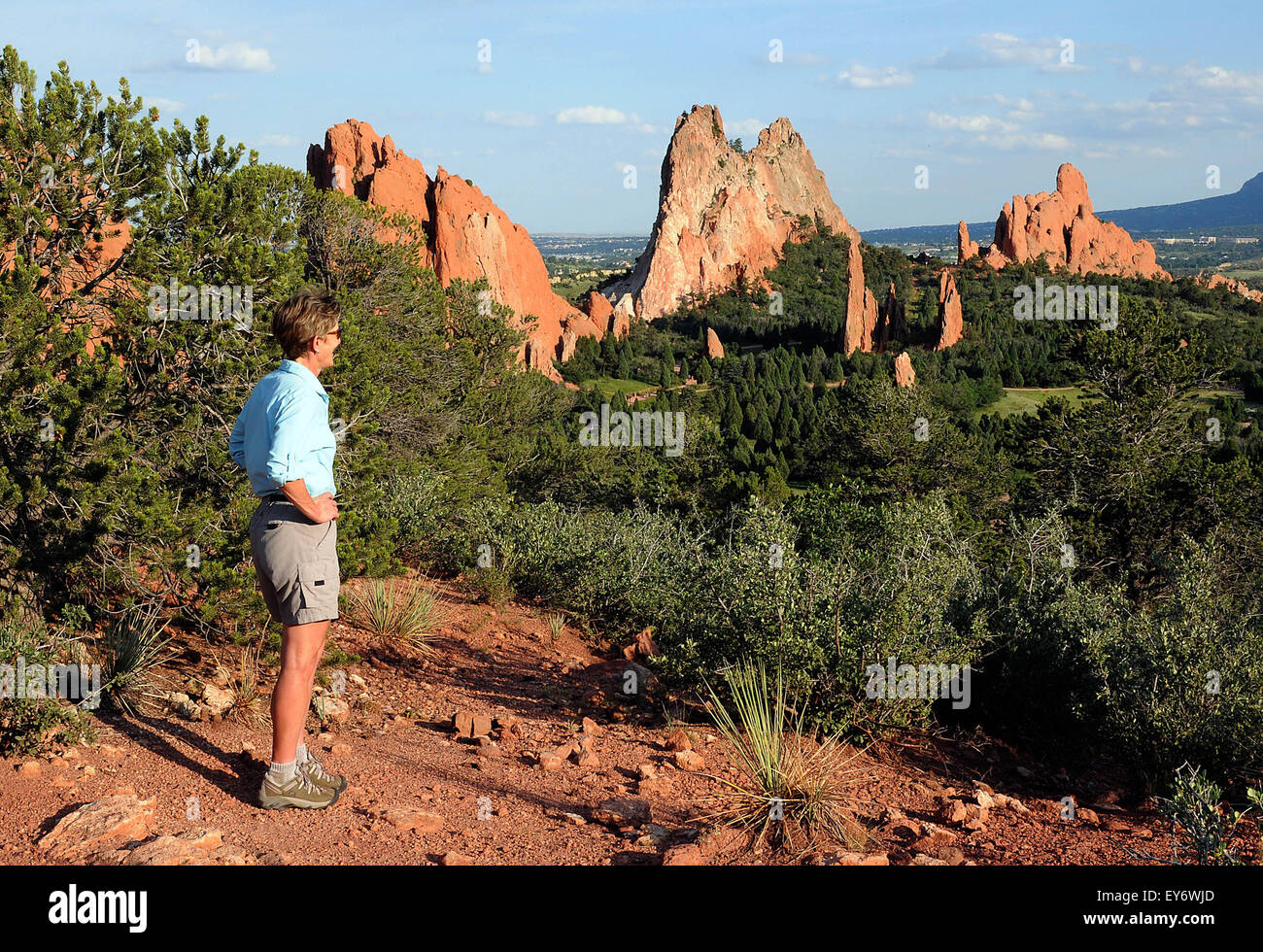 A hiker enjoys the expansive view into the Central Garden from one of the many trails in the Garden of the Gods. The Garden of the Gods is one of the most popular city parks in the United States and offers urban hiking, rock climbing, horseback riding and cycling within just a few minutes of the city of Colorado Springs, Colorado. Stock Photo