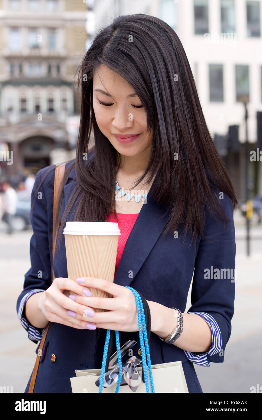 young chinese woman in the street holding a coffee Stock Photo