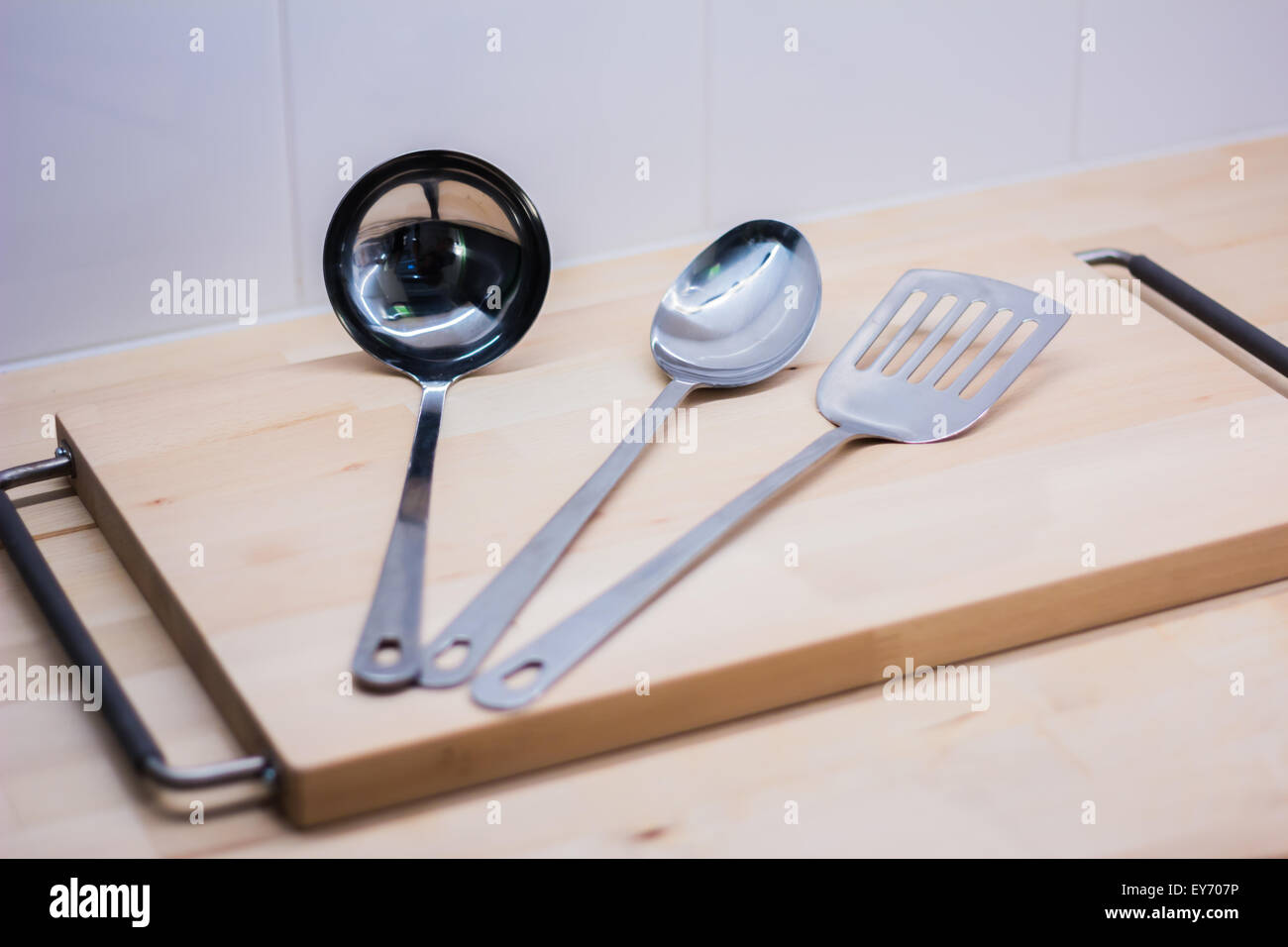 Stainless kitchenware on wooden board Stock Photo