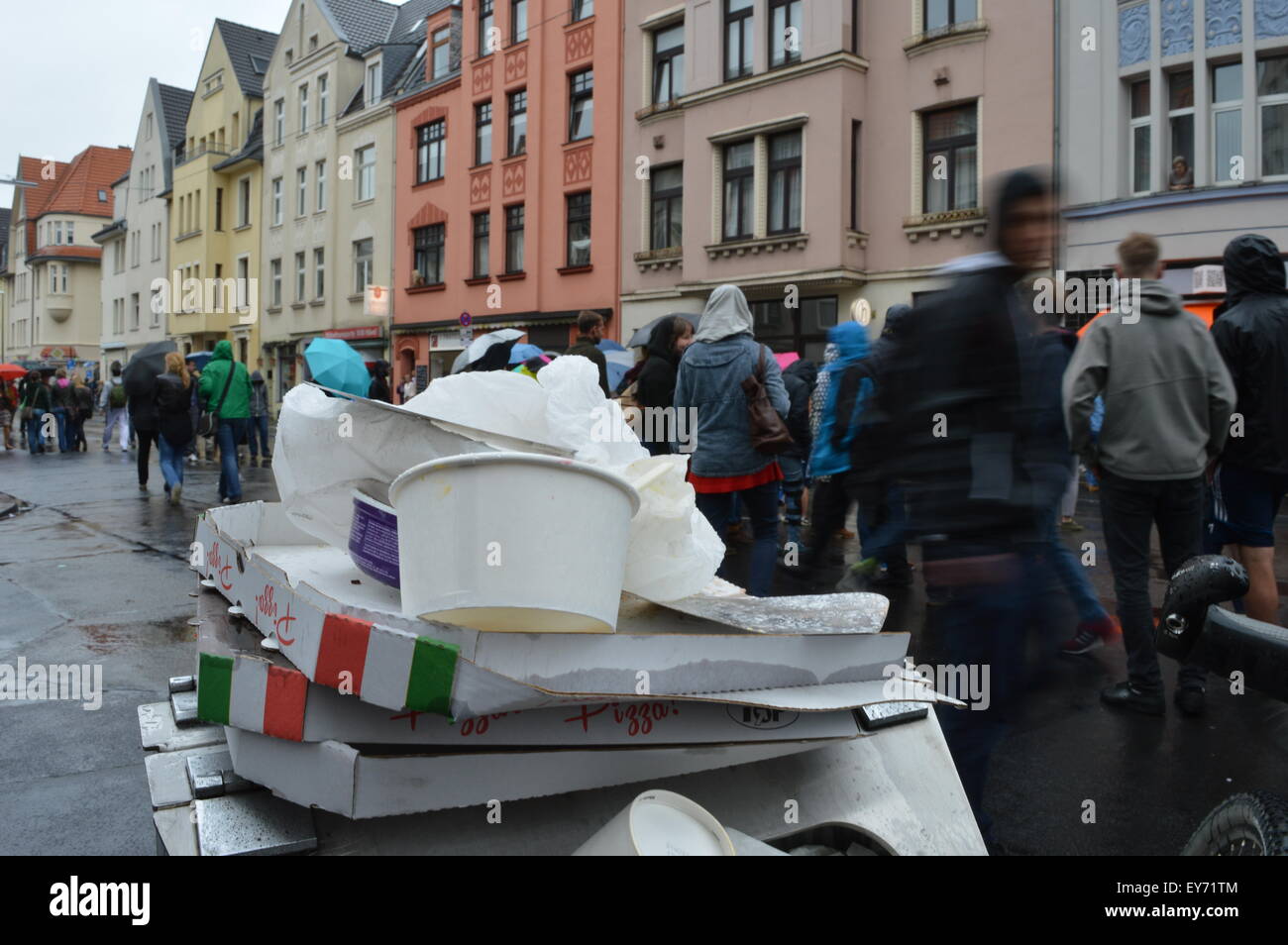 Cologne, Germany - May 31, 2015 - Waste as a mean problem in big cities and metropoles with people walking by during rain Stock Photo