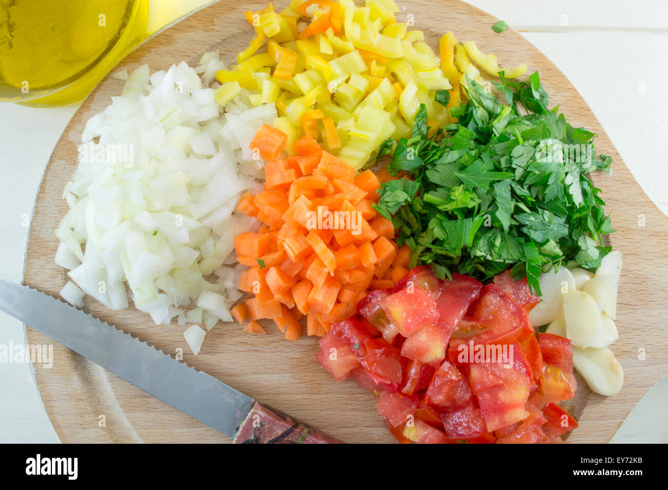Chopped vegetables on an wooden plate with a knife  ready for cooking Stock Photo