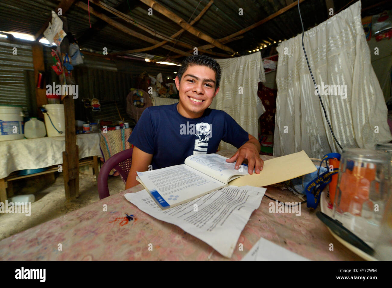 Teenager, 17 years, doing homework in his hut, slum Colonia Monsenor Romero, Distrito Itália, San Salvador, El Salvador Stock Photo