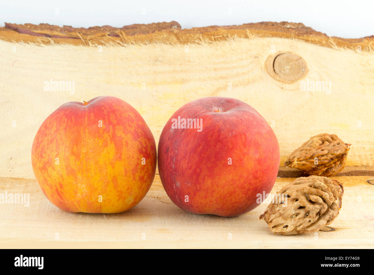 Fresh peaches and peach kernels  on a natural wooden board Stock Photo