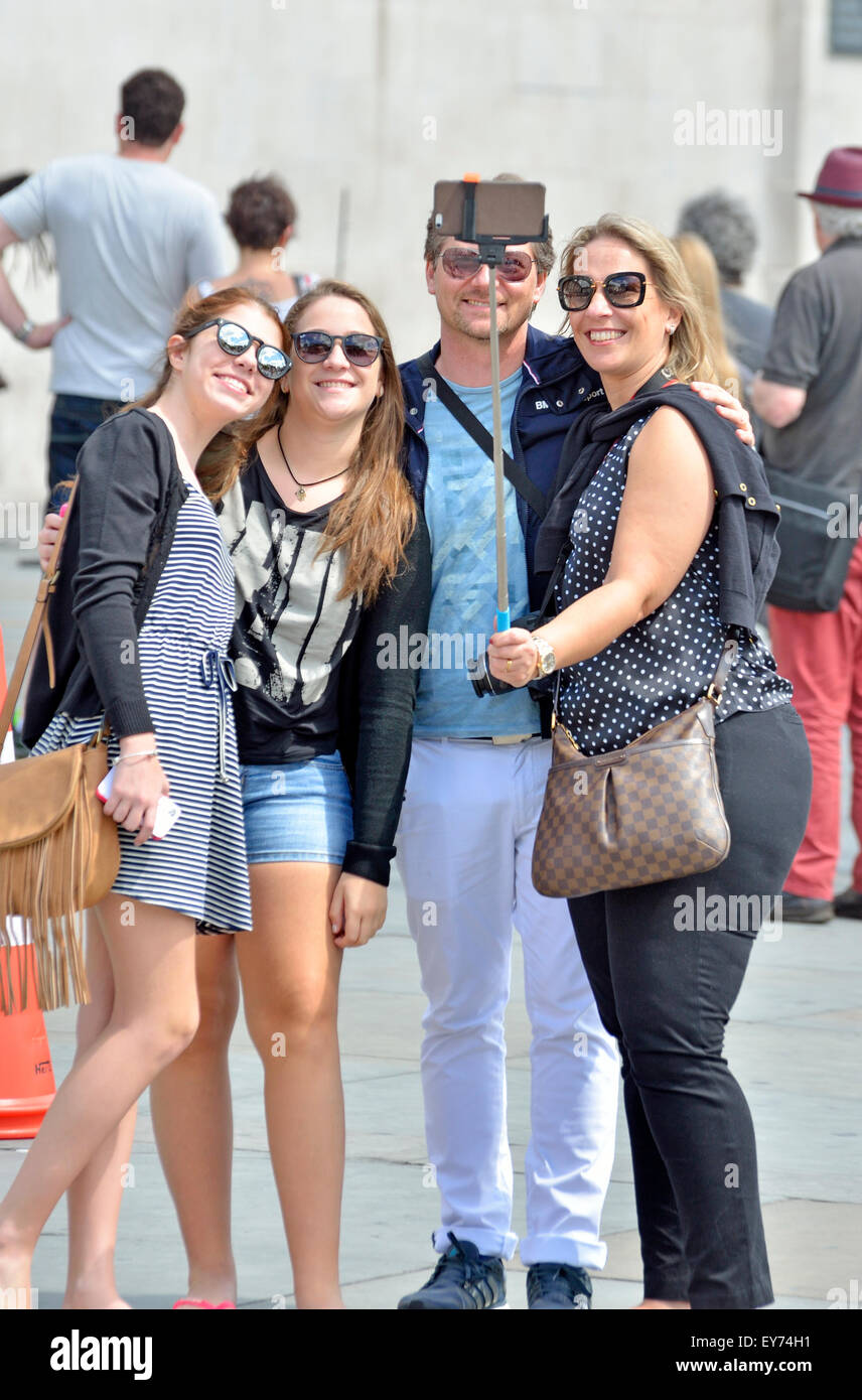 London, England, UK. Family in Trafalgar Square taking a photo with a selfie stick Stock Photo