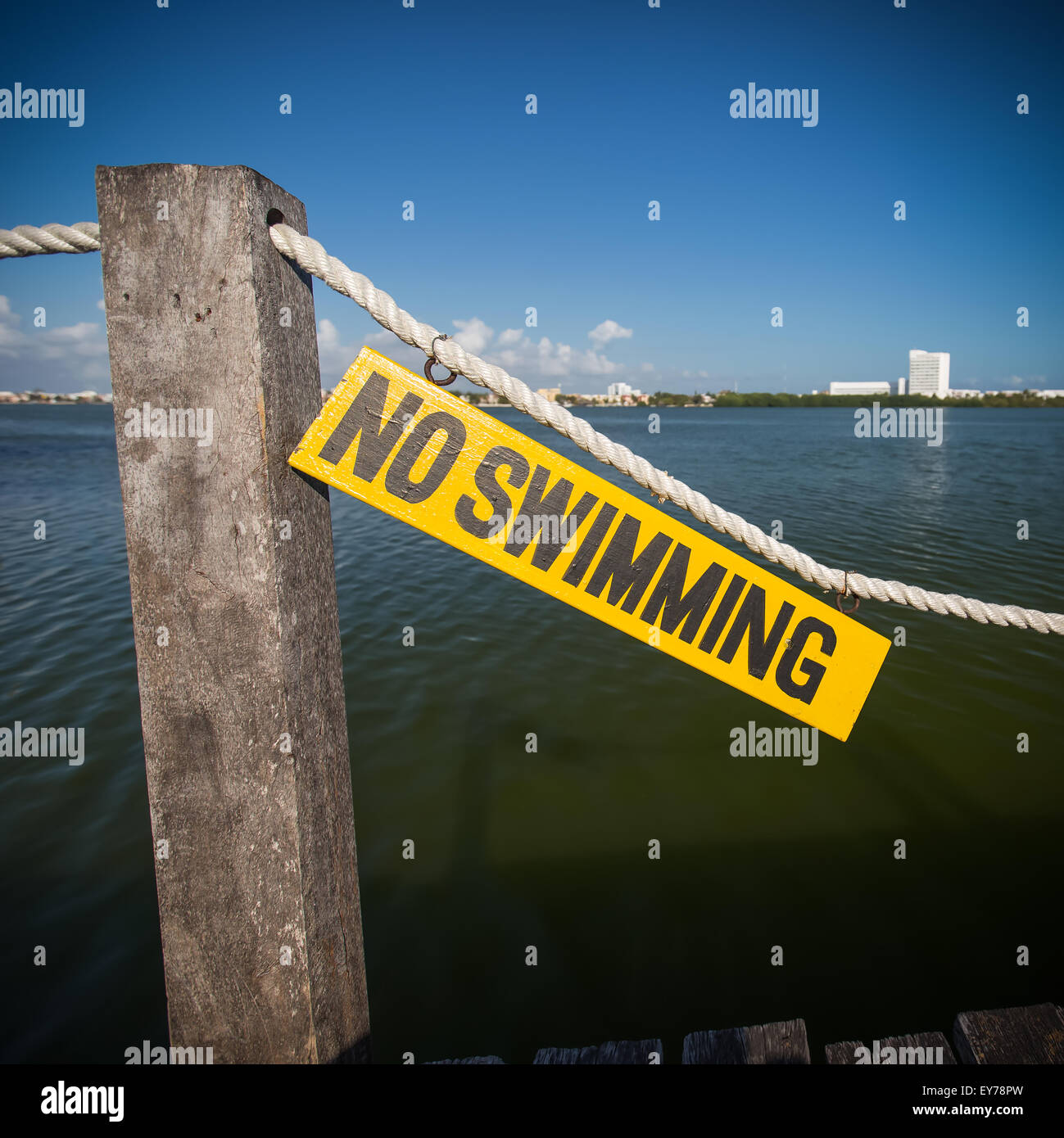 No swimming sign on wooden tablet near lagoon Stock Photo