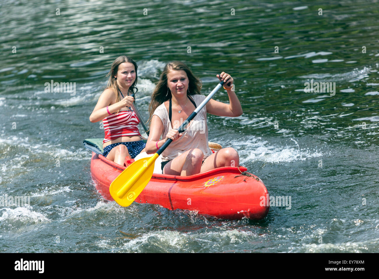 Two girls canoeing river Vltava South Bohemia, Czech Republic young women canoeing down a floating river Stock Photo