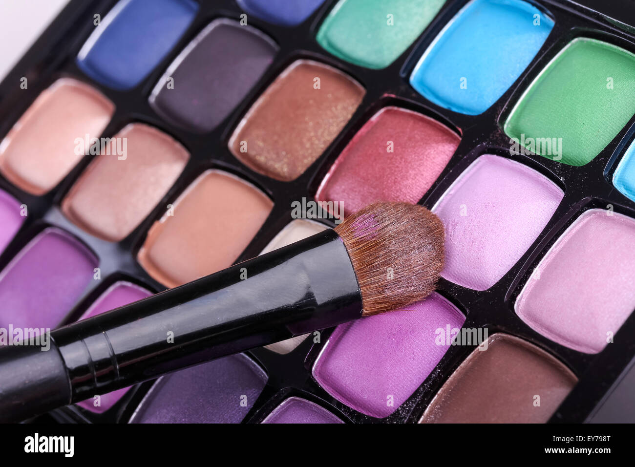 Multicolored eye shadows with cosmetics brush, closeup Stock Photo