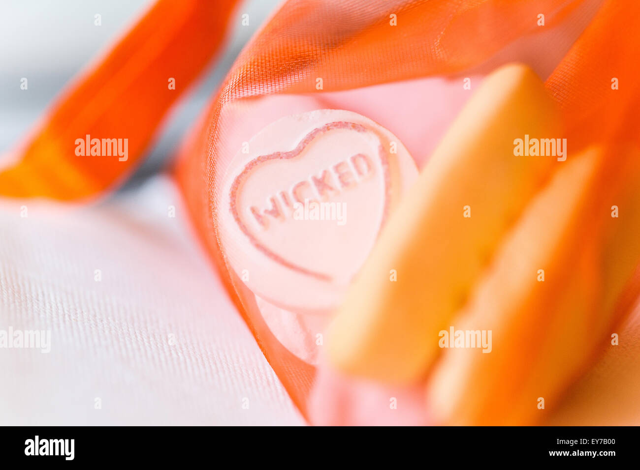 A Swizzels Matlow love heart sweet  printed with the word Wicked and left on a wedding table as a gift for the guest. A surprise reception treat Stock Photo
