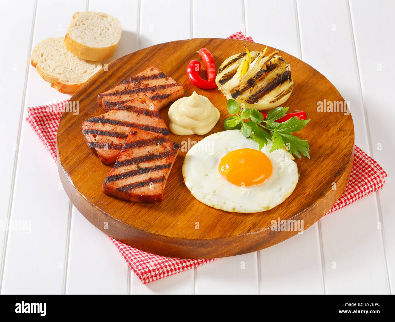 Grilled meatloaf with sunny side up fried egg and mustard Stock Photo