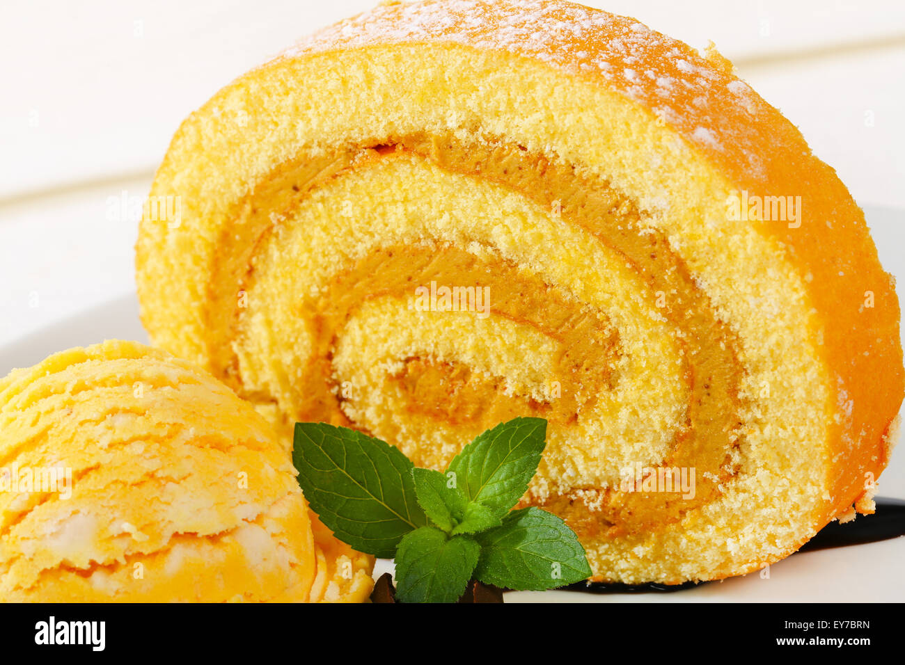 Slice of Swiss roll with yellow ice cream Stock Photo Alamy