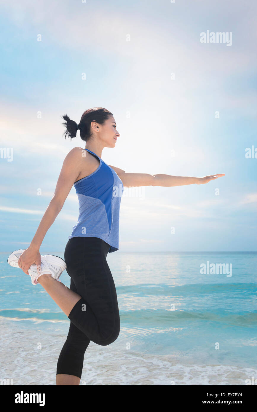 Young woman exercising by sea Stock Photo