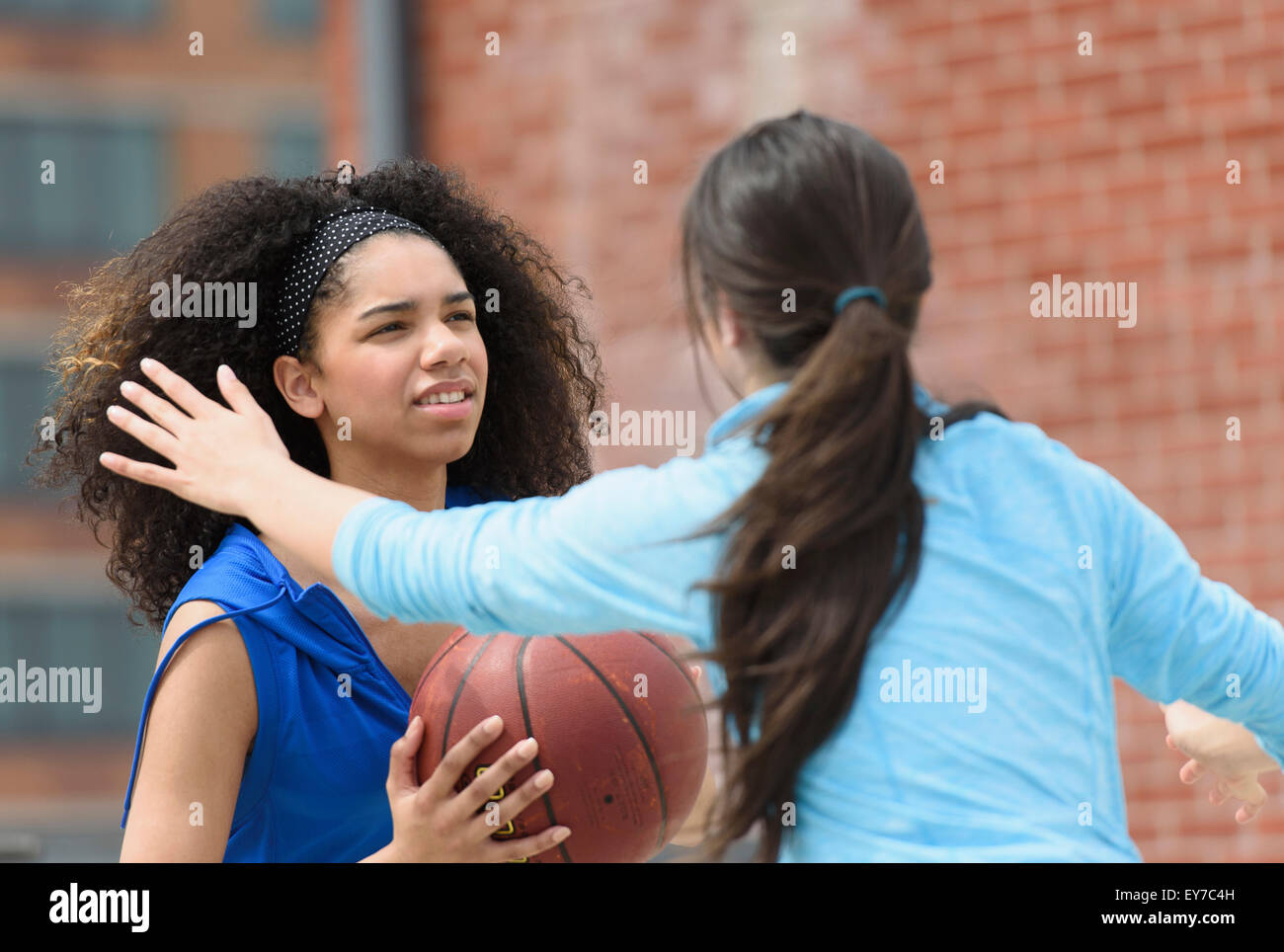 Teenage girls (14-15, 16-17) playing basketball Stock Photo