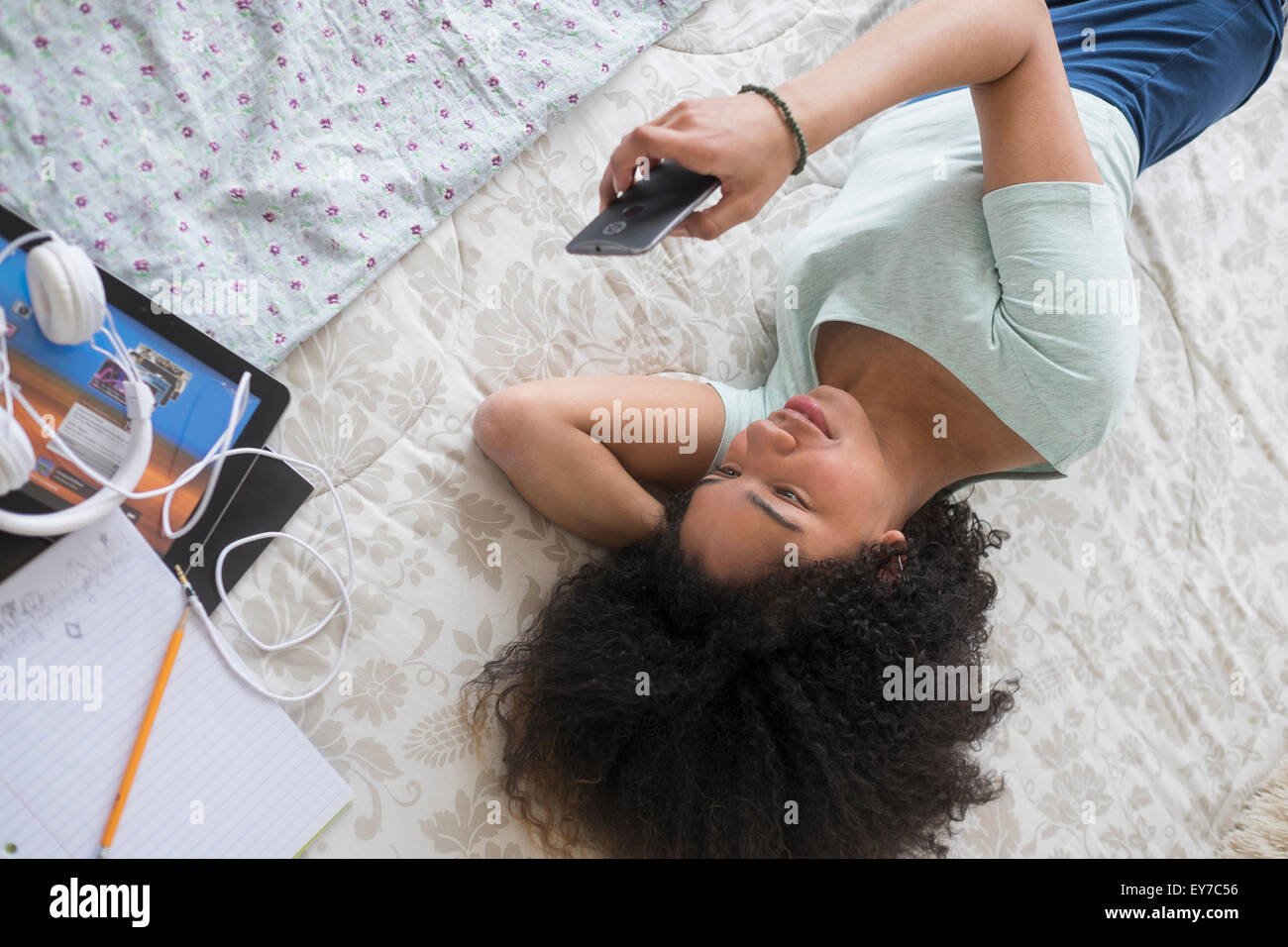 Teenage girl (16-17) texting in bedroom Stock Photo