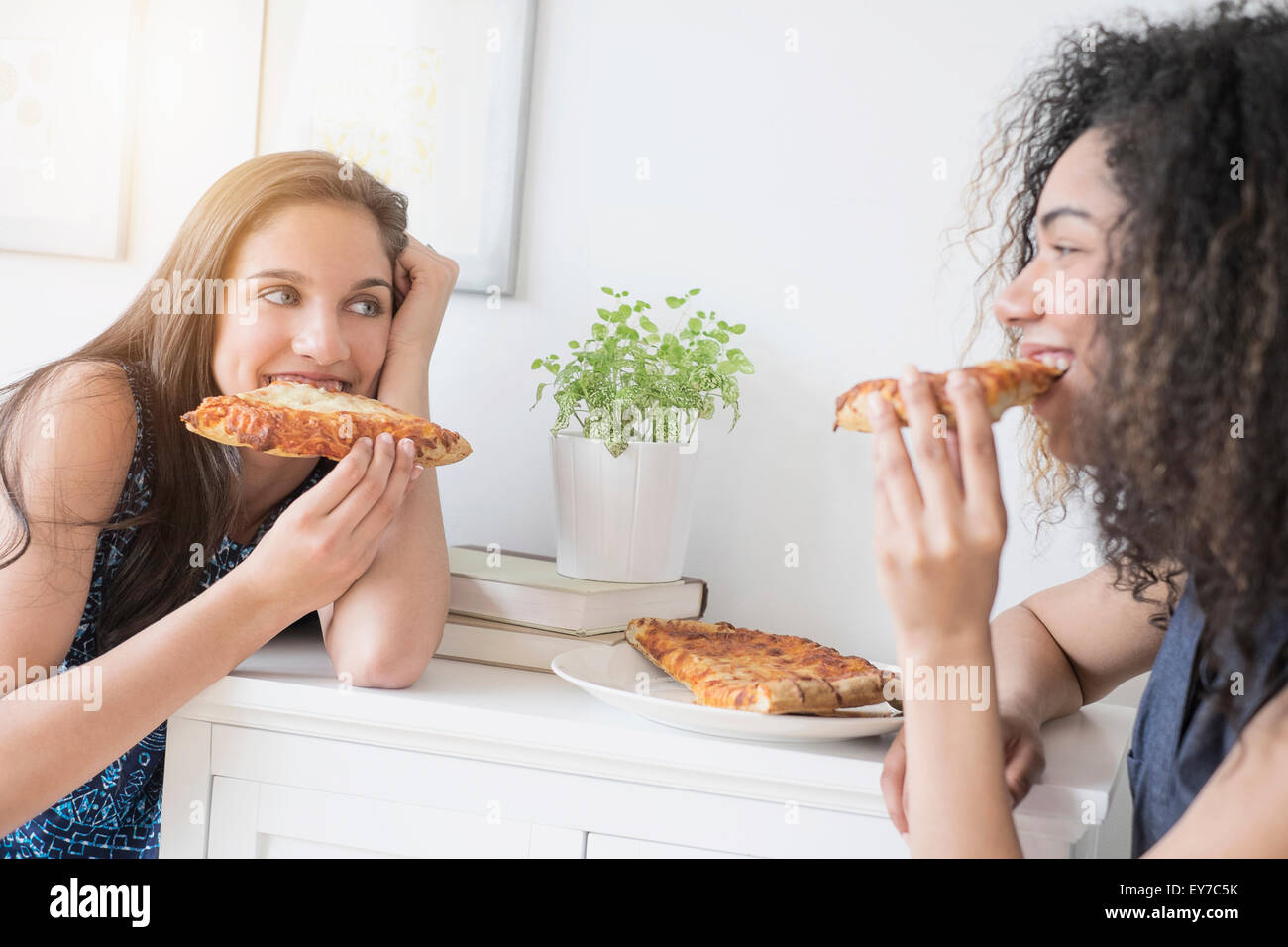 Teenage girls (14-15, 16-17) eating pizza Stock Photo