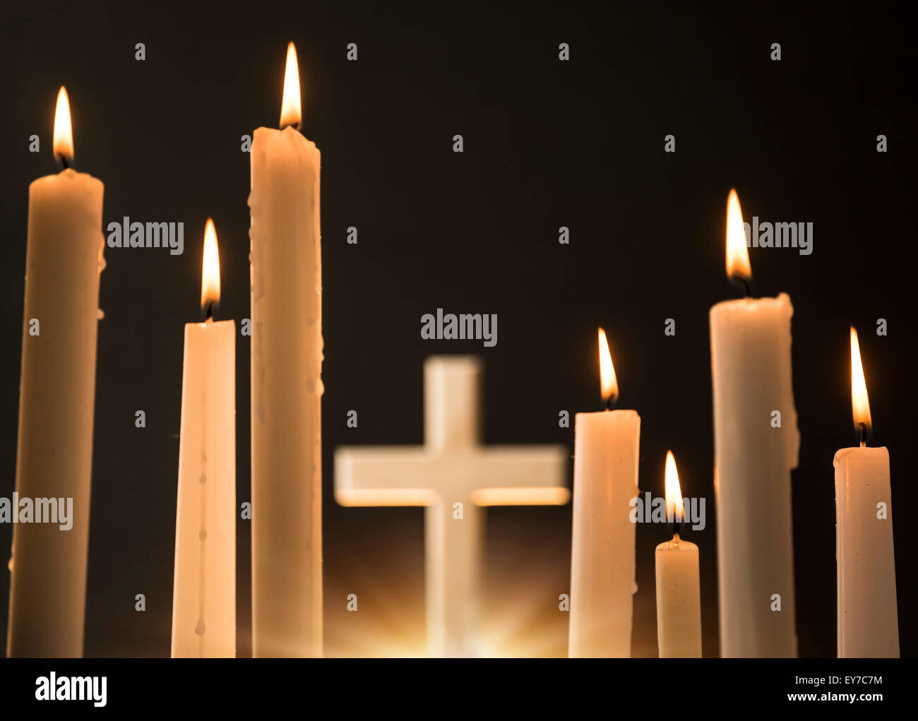 Burning candles with cross in background Stock Photo Alamy