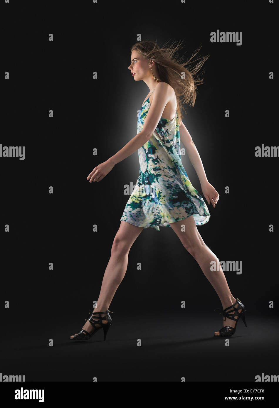 Studio shot of young woman walking Stock Photo