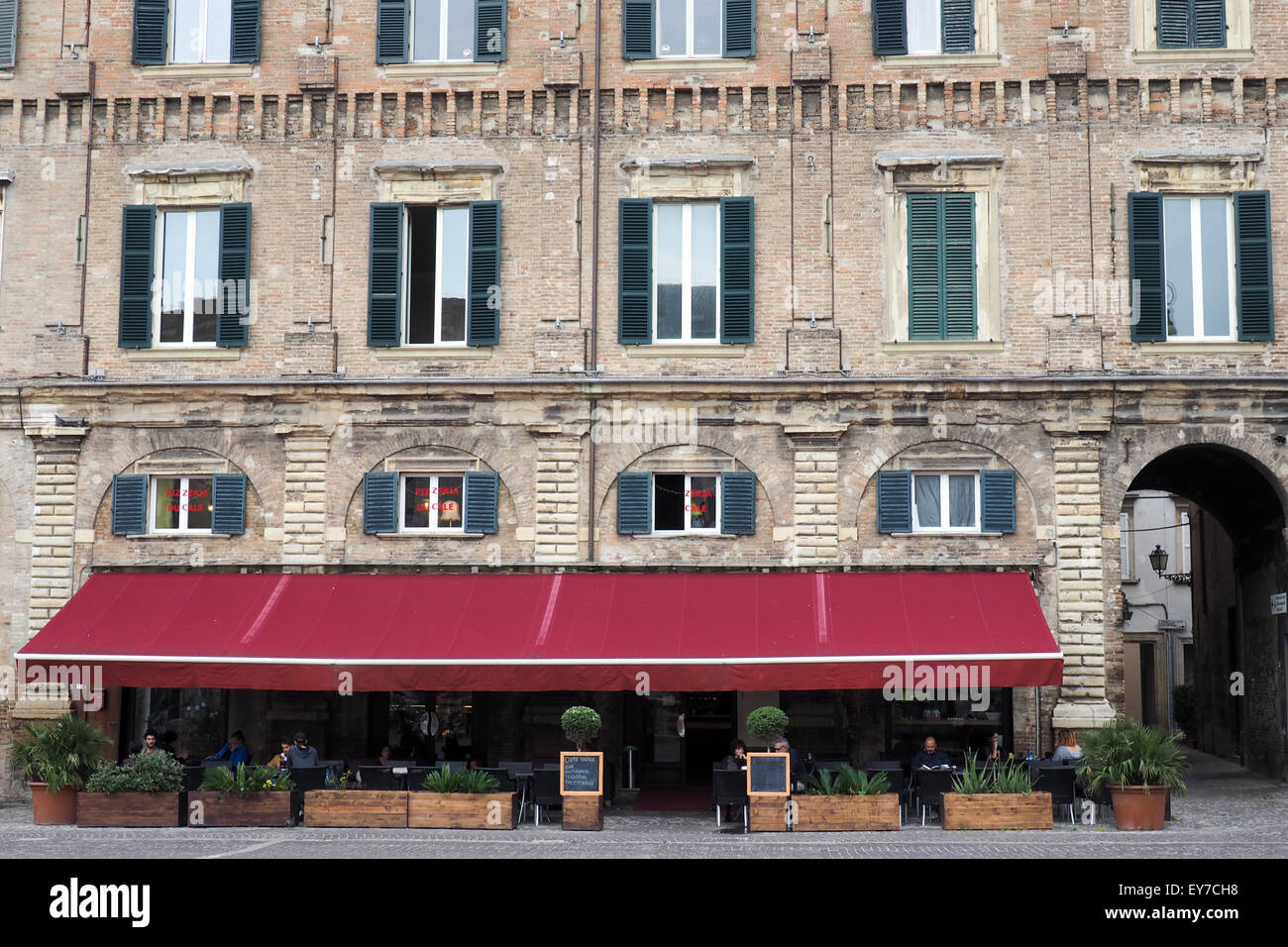 Large red awning over a restaurant,in a piazza. Stock Photo