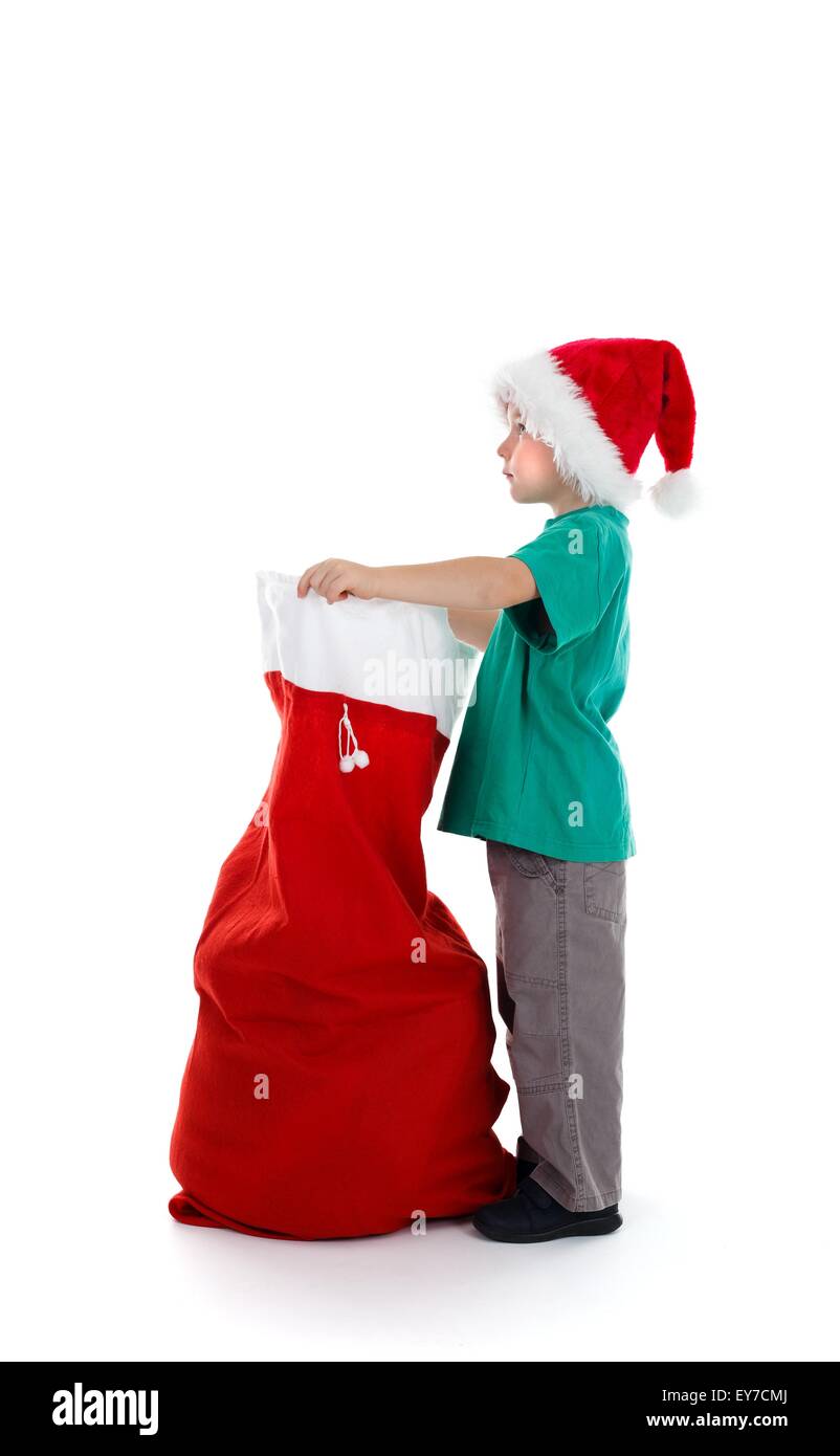 Child with full Santa hat holding red Santa sack Stock Photo