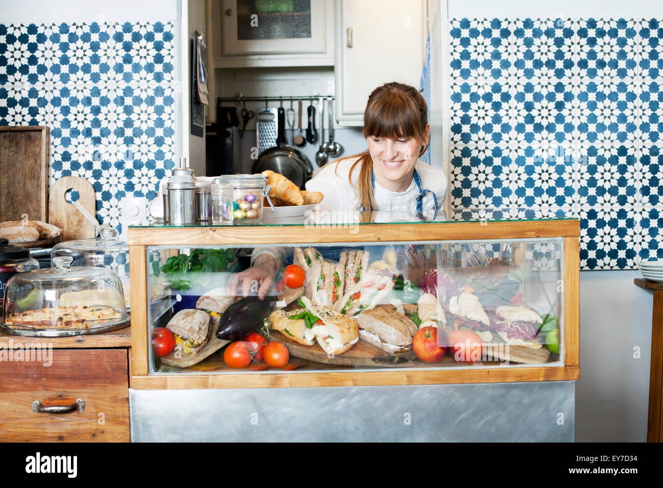Woman behind counter in coffee shop Stock Photo