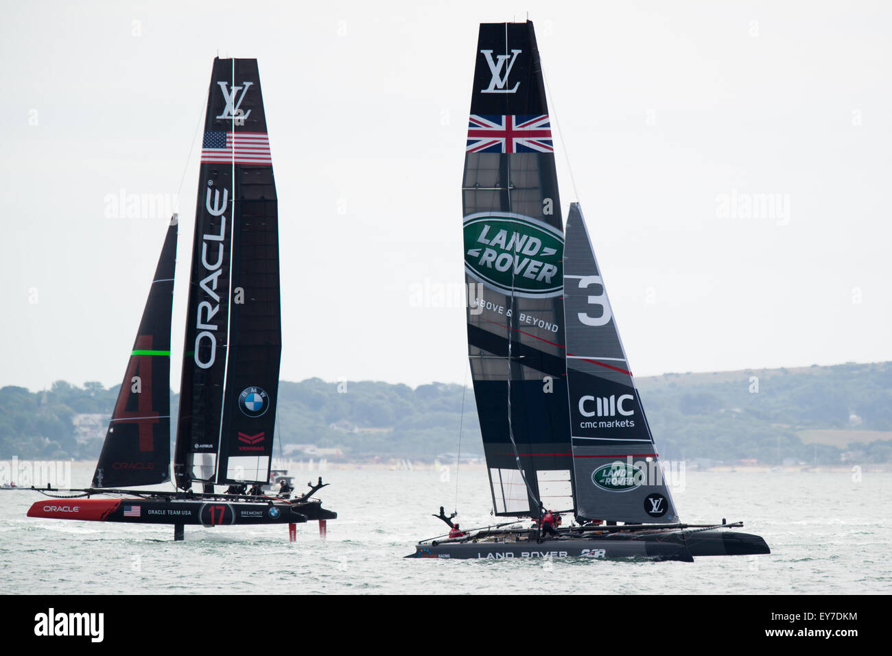 Portsmouth, UK. 23rd July 2015. Current holder Oracle Team USA passes Land Rover BAR (Ben Ainslie Racing) the UK challenger for the America's Cup during the Parade of Sail on day one. Credit:  MeonStock/Alamy Live News Stock Photo