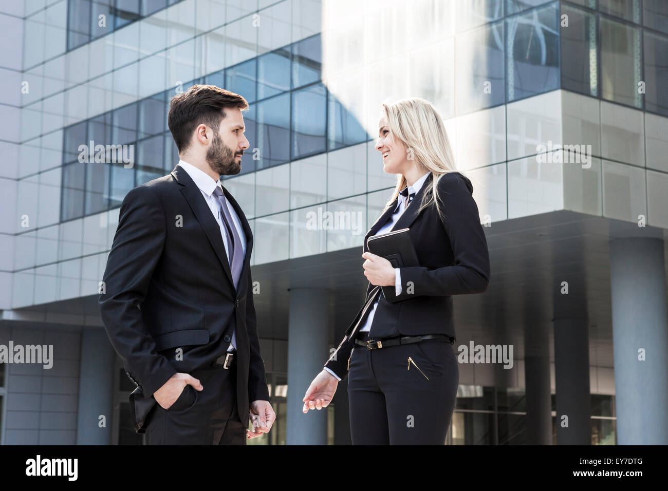 Business partners talking against office building Stock Photo