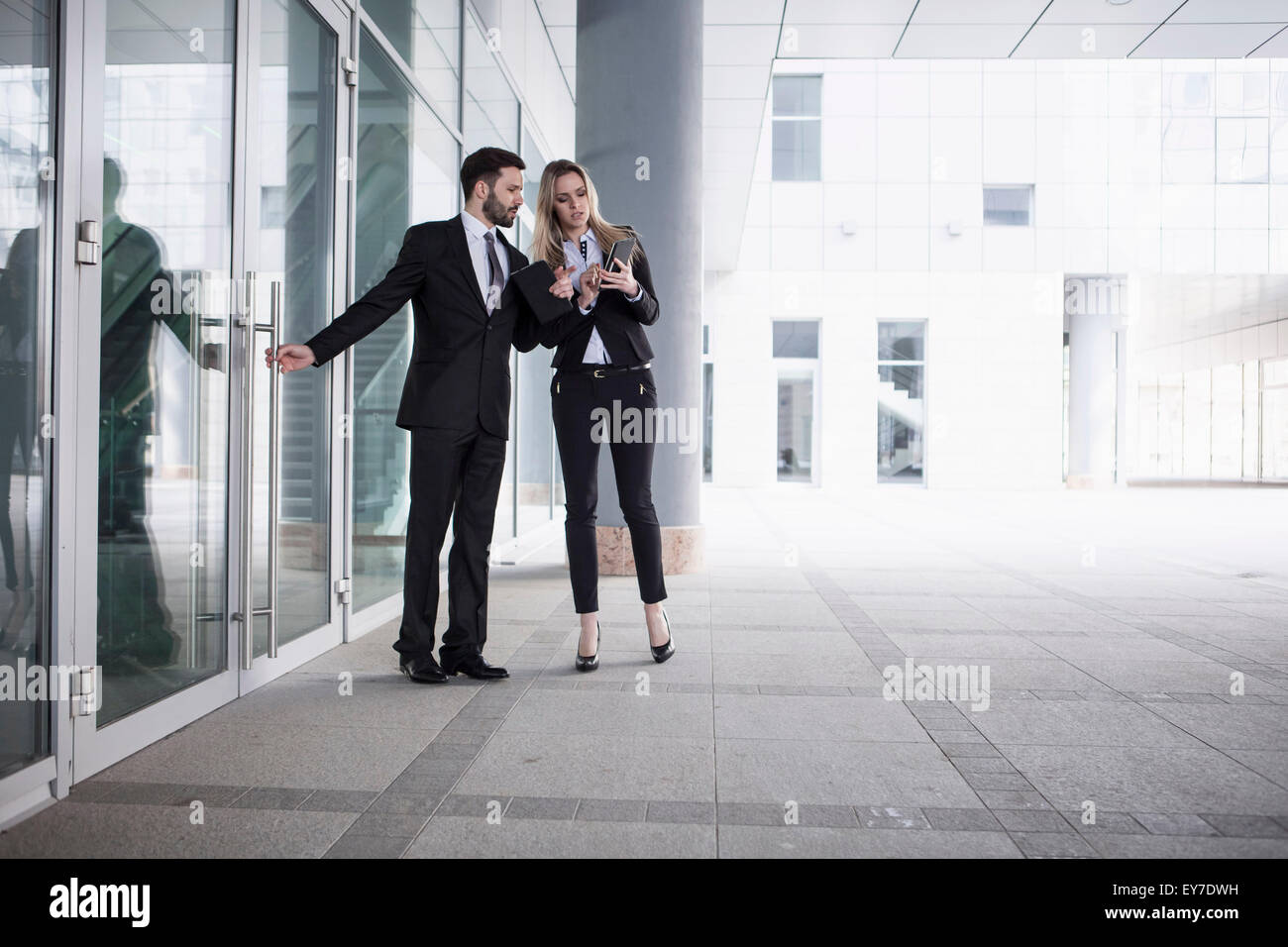 Business partners looking at digital tablet outdoors Stock Photo