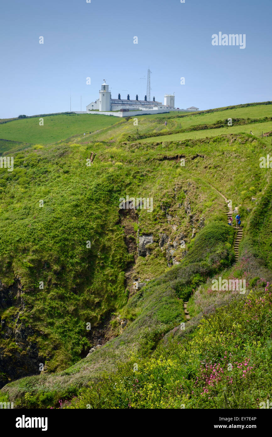 Lizard Point Lighthouse, Lizard Peninsula, Cornwall, England, UK with walkers on the South West Coast Path Stock Photo