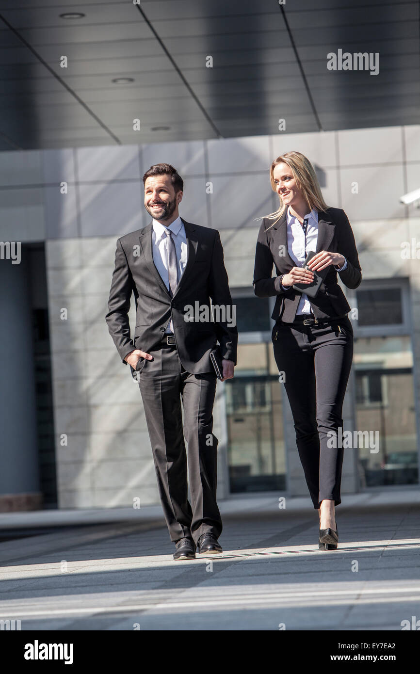Business partners walking against office building Stock Photo - Alamy