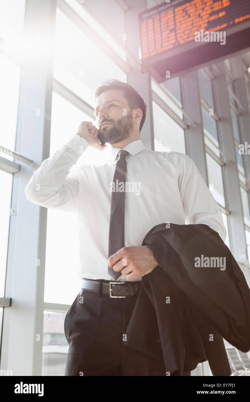 Businessman using mobile phone in airport Stock Photo