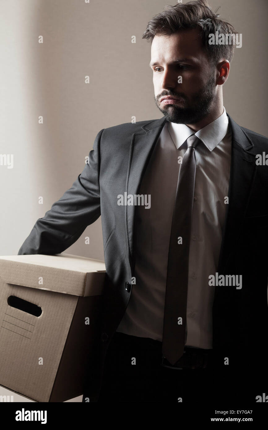 Businessman carrying cardboard box Stock Photo