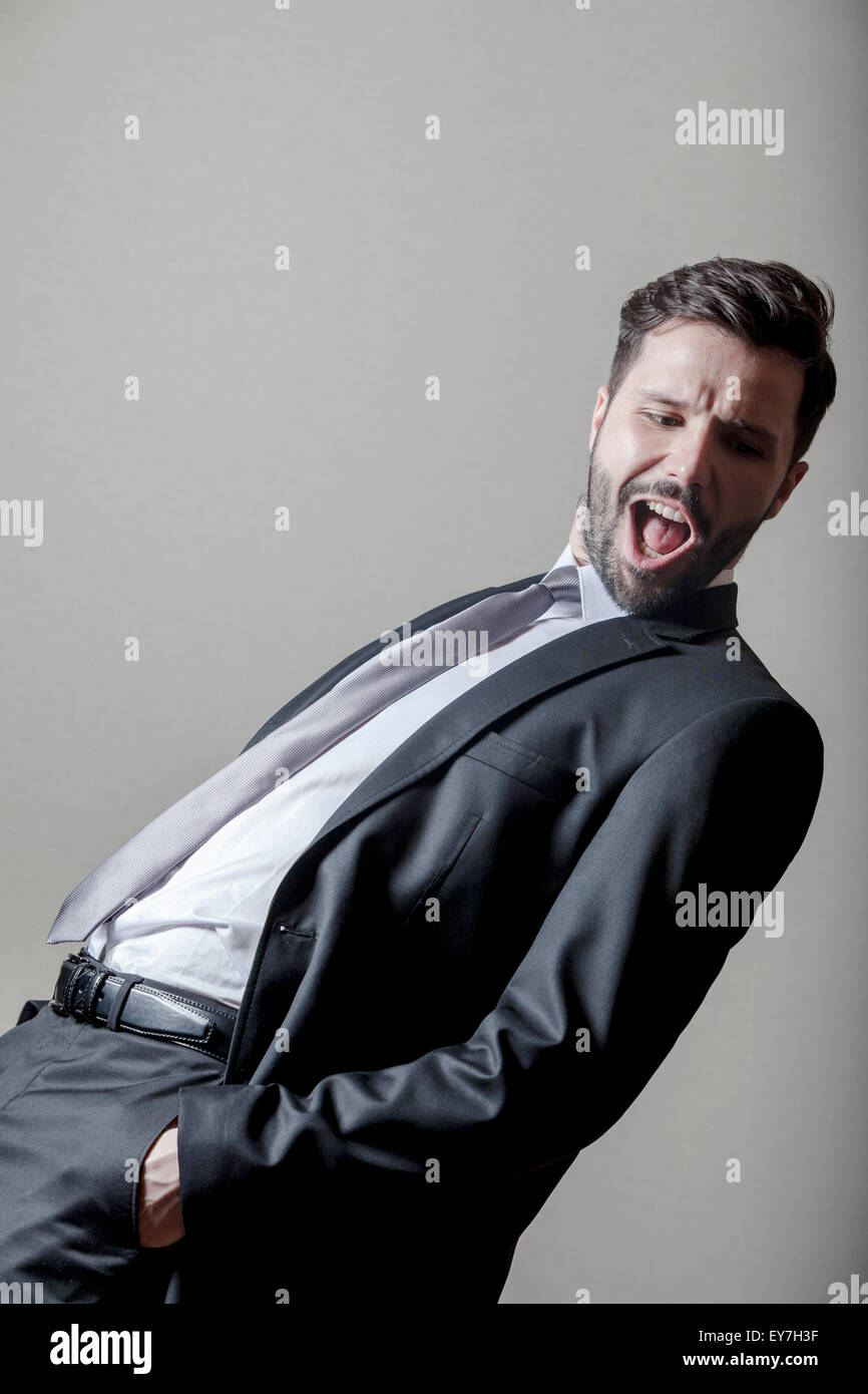 Businessman with hands in pockets mouth open Stock Photo Alamy