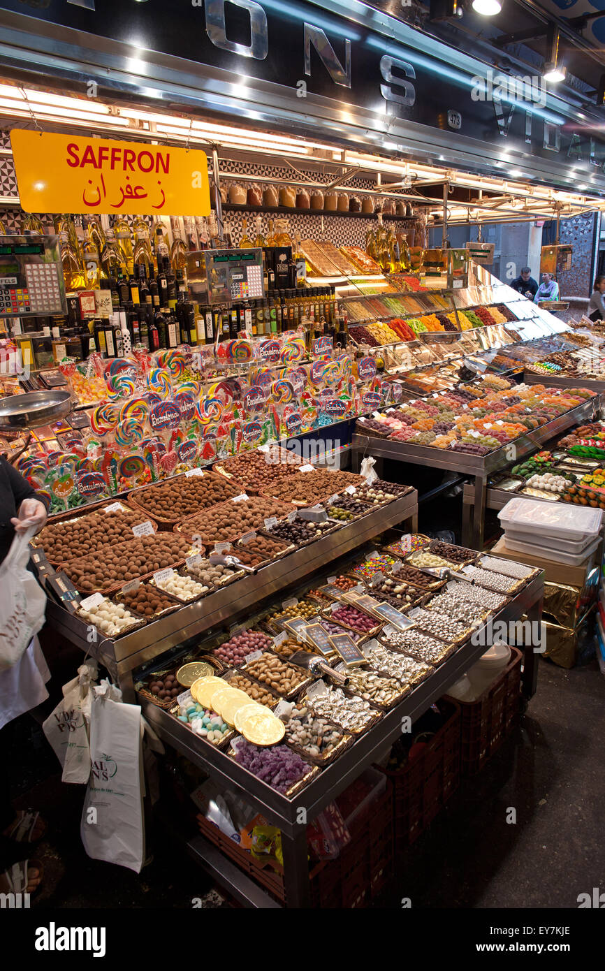 Stall with dried fruits, nuts, candies and alcohol in La Boqueria food market in Barcelona, Catalonia, Spain Stock Photo