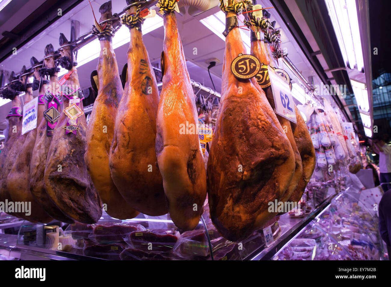 Traditional dry cured whole leg hams in La Boqueria food market in