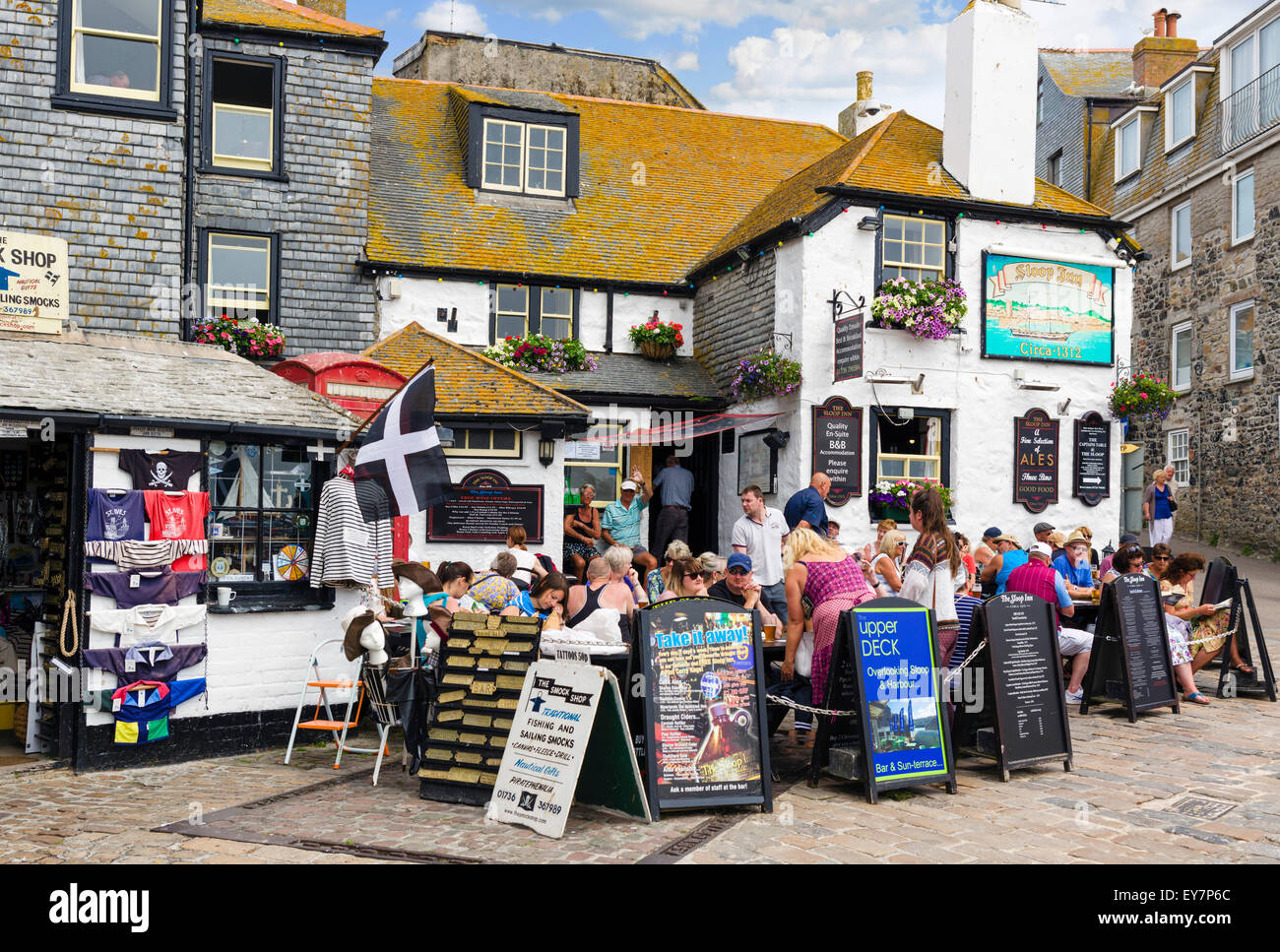 People sitting outside the historic Sloop in on the seafront, Wharf Road, St Ives, Cornwall, England, UK Stock Photo