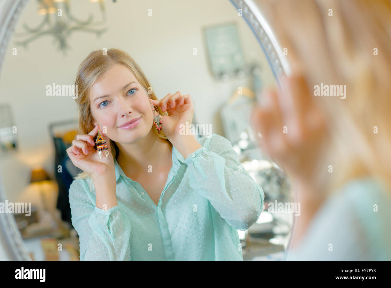 Lady holding earrings to ears Stock Photo Alamy