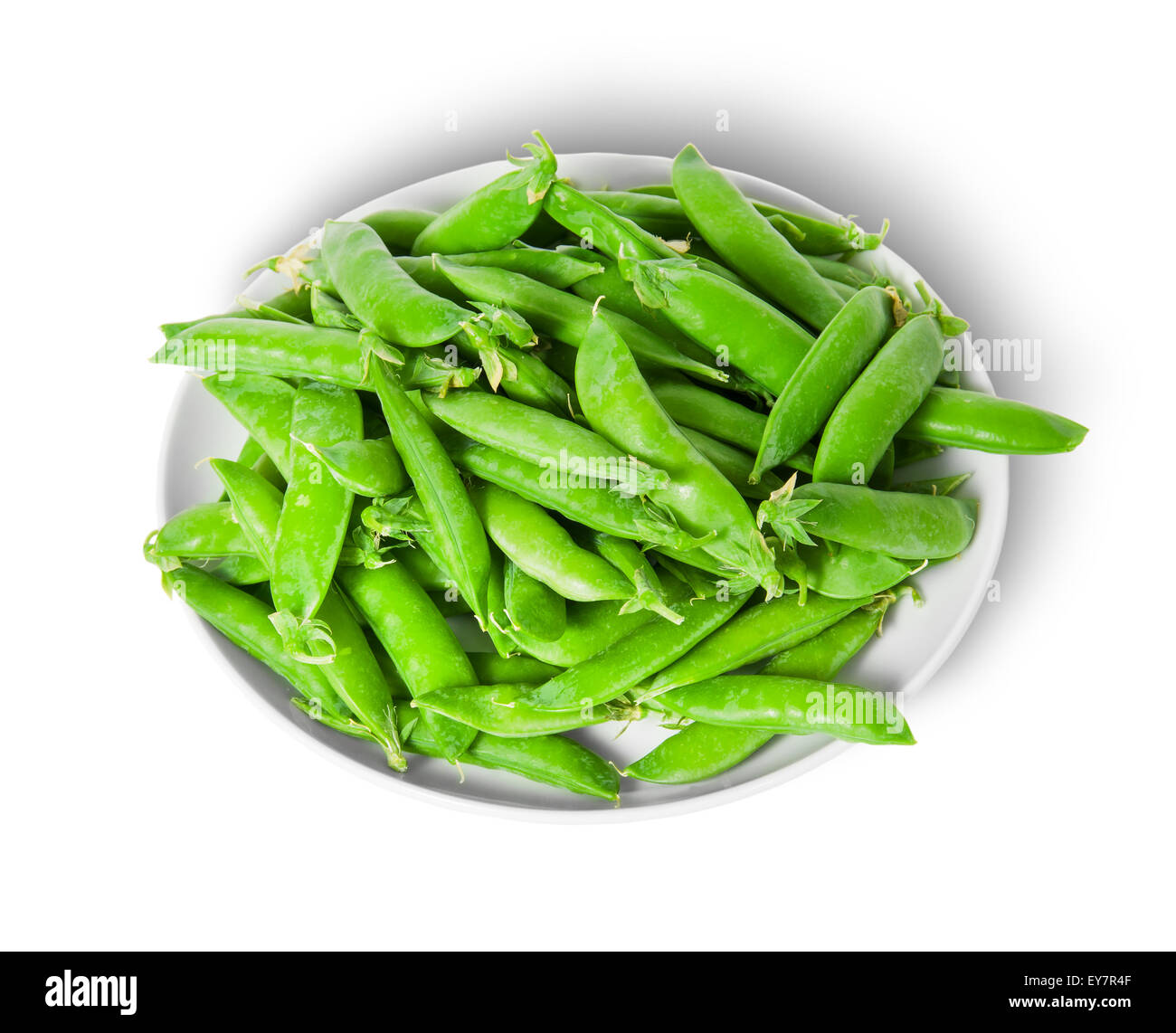 Small pile of green peas in pods on white plate isolated on white background Stock Photo