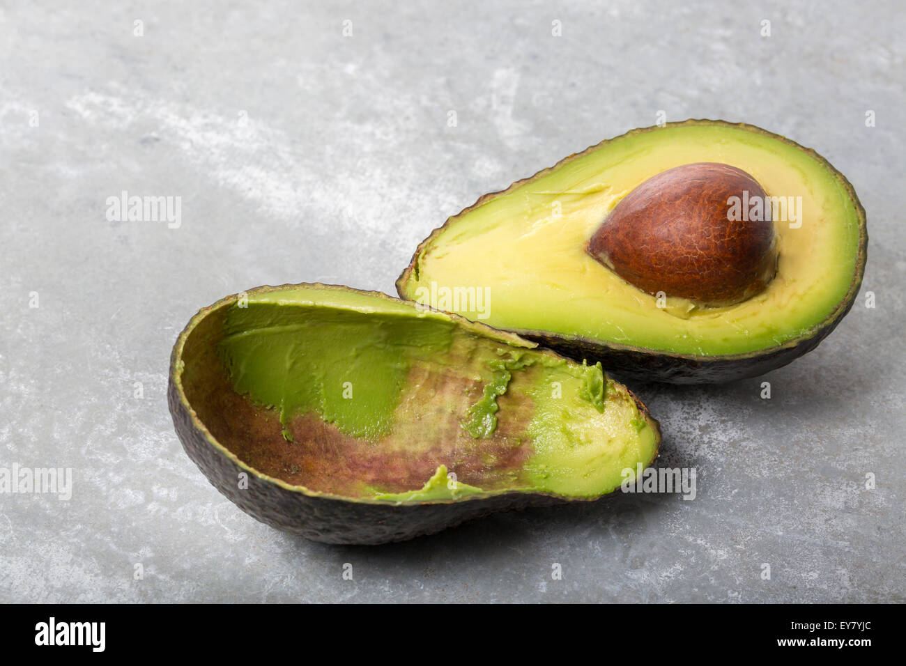An Avocado cut in two halfs Stock Photo Alamy