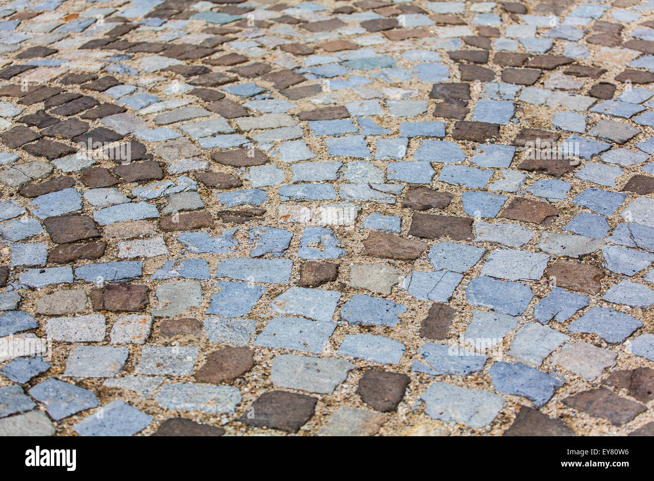 Stone pavement texture. Granite cobblestoned pavement background. Abstract background of old cobblestone pavement close-up. Stock Photo