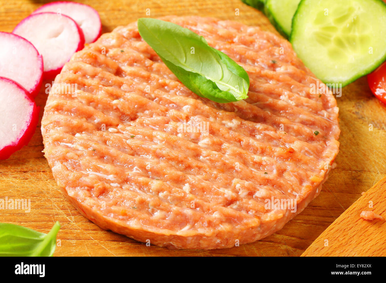 Raw burger patty and sliced vegetables on cutting board Stock Photo Alamy