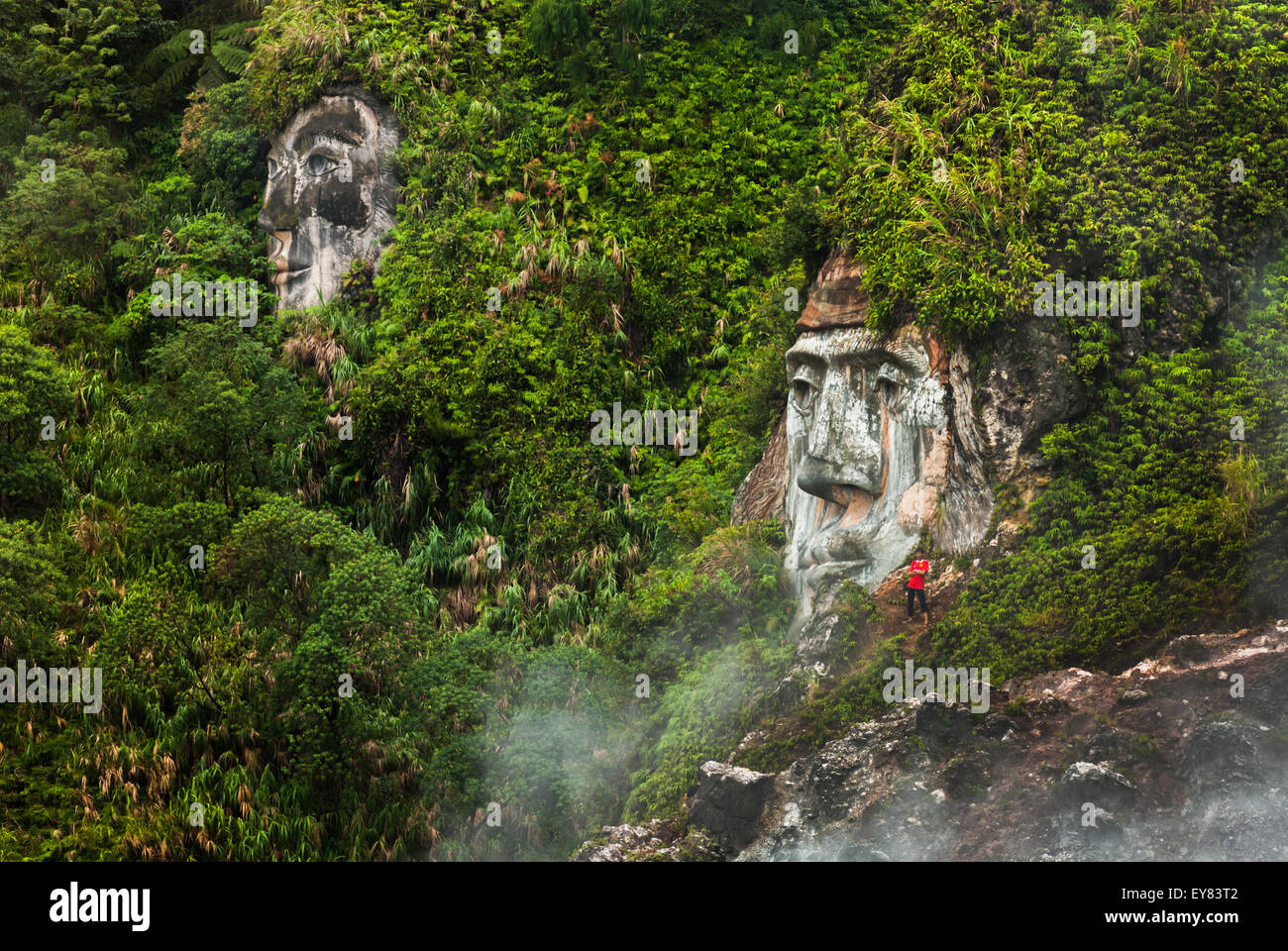 A visitor is spotted near a giant face formation illustrating the character of Toar (ancestral figure) at Bukit Kasih, North Sulawesi, Indonesia. Stock Photo