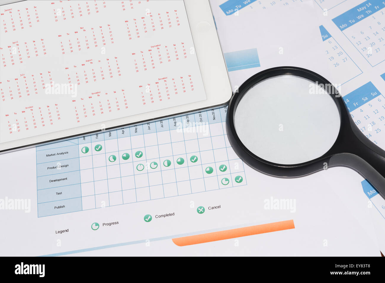 Project schedule with magnifier and calendar on the tablet screen Stock Photo