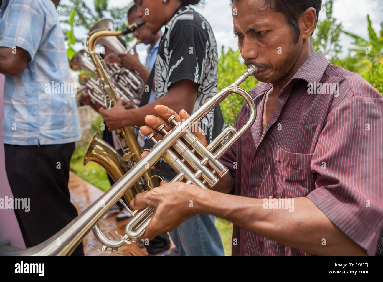 Villagers playing trumpet and saxophone during a rural orchestra performance to welcome tourists in Rumahkay, West Seram, Maluku, Indonesia. Stock Photo