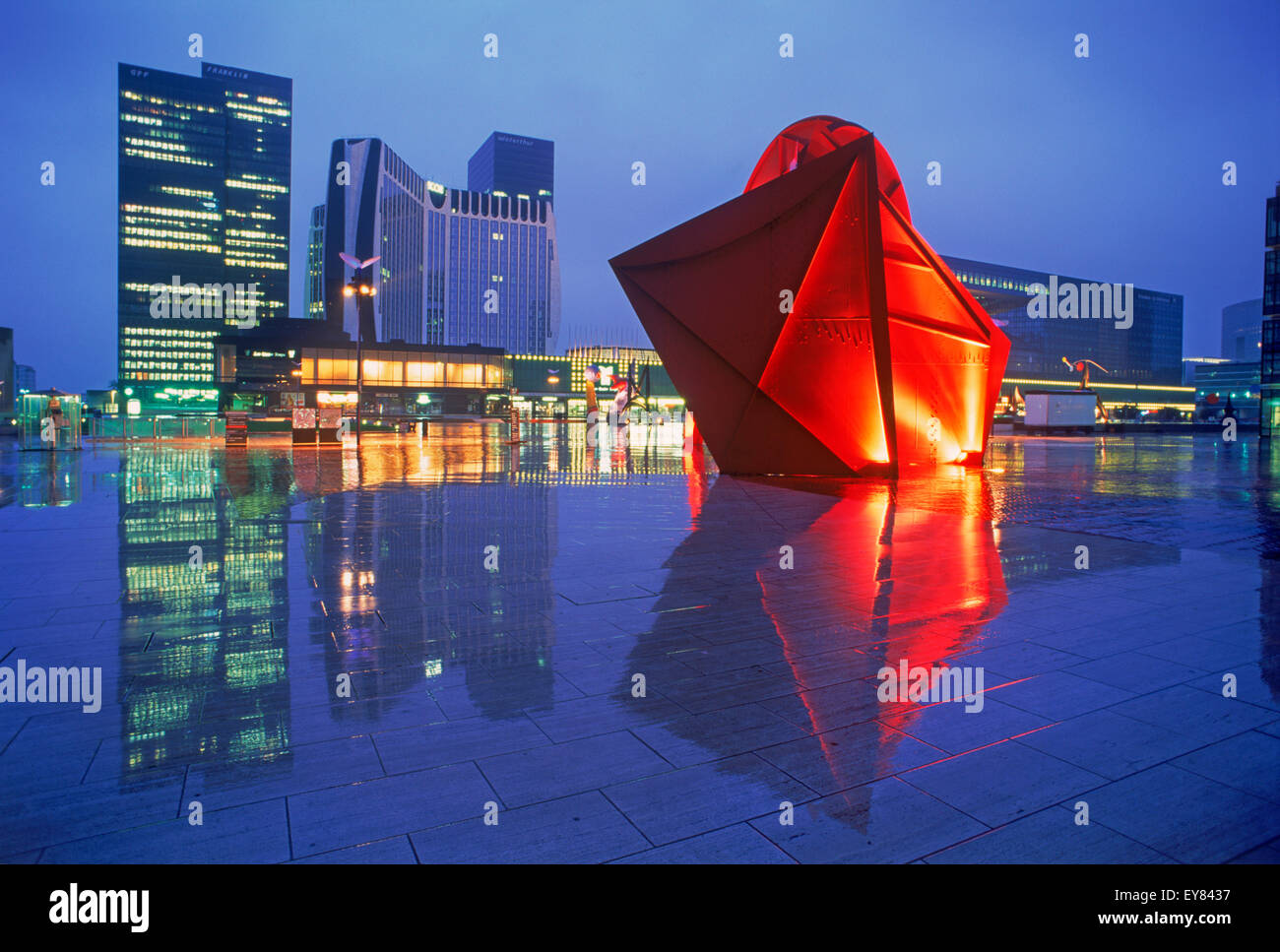 The Arch and modern sculptures at La Defense reflecting of wet surface on rainy night Stock Photo