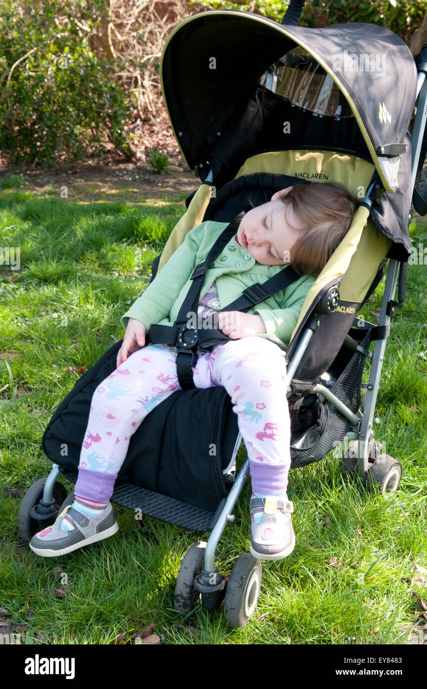 Toddler asleep in her pushchair Stock Photo