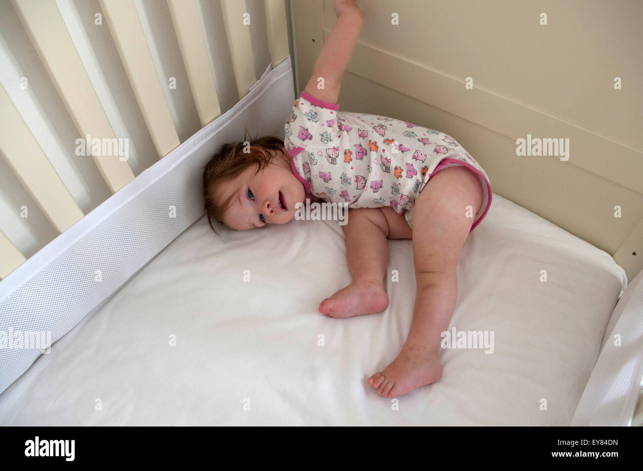 Overhead shot of baby girl lying down in her cot Stock Photo