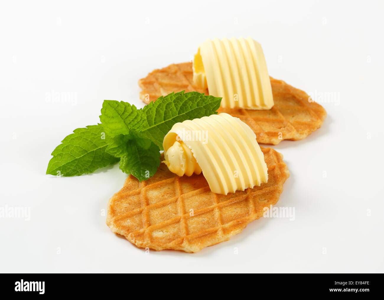 Thin waffle crisps and curls of fresh butter Stock Photo