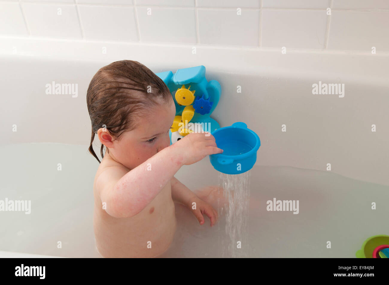 Toddler playing in the bath with bath toys Stock Photo Alamy