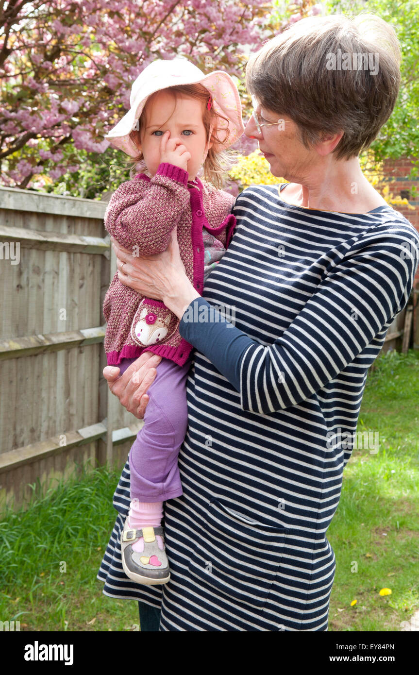 Little girl being comforted and held by her grandmother Stock Photo