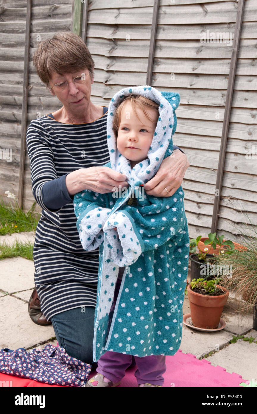 Little girl trying on a new dressing gown with her grandmother Stock Photo